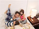 Mid adult man tickled in bed by son and daughter