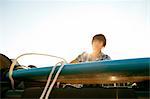 Teenager untying his board from roof of jeep