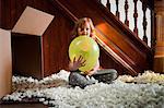 Girl playing with balloon and packing material from cardboard box