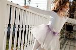 Girl dancing in ballet costume on porch