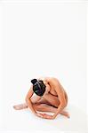 Young nude woman stretching in yoga position