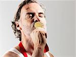 Mature man kissing gold medal against white background