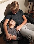 Boy looking up at older brother sitting on beanbag