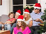 Family wearing Santa hats on sofa
