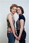 Portrait of lesbian couple holding hands, studio shot