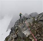 Female climber crossing rock ridge, Picket Pass, North Cascades National Park, WA, USA