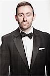 Portrait of man in tuxedo against white background