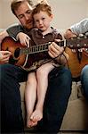 Father teaching son to play guitar