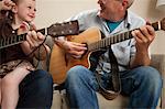 Boy and grandfather playing guitar