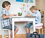 Brothers doing their homework in kitchen