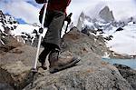 Woman takes a step with trekking poles at the Monte Fitz Roy Lookout in Los Glaciares National Park, El Chalten, Argentina