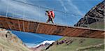 Woman crosses bridge over the Horcones River,  Aconcagua in the Andes Mountains, Mendoza Province, Argentina