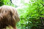 Young woman looking up at trees