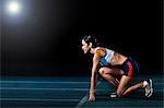 Female athlete in starting position on running track