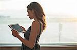 Young woman using digital tablet by window