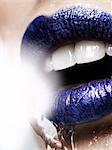 Water pouring over young woman in blue lipstick, close up