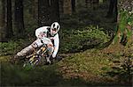 Mountain biker riding muddy forest track
