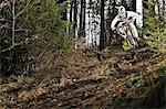 Mountain biker riding down forest track