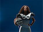 Portrait of female american football player with shoulder pads and helmet