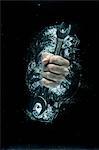 Male hand gripping wrench beneath water