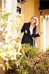 Mature businesswoman leaving house, smiling