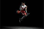 Young male basketball player mid air