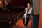 Mature woman standing in theatre aisle