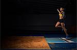 Young female athlete doing long jump