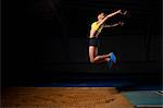 Young female athlete doing long jump