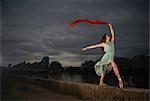 Ballet dancer holding red scarf on wall