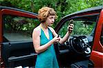 Woman in forest looking at compact mirror