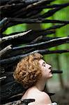 Close up portrait of woman in forest in front of log pile