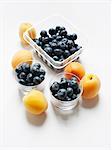 Still life with apricots and blueberries in glass tumblers