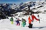 Group of skiers climbing mountain with ski equipment