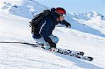 Male skier speeding down mountain