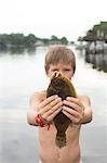 Portrait of boy holding up flounder, Shalimar, Florida, USA