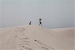 Boy and girl playing, White Sands National Park, New Mexico, USA