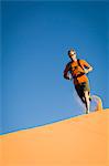 Male hiker running across Star Dune, Coral Pink Sand Dunes State Park, Utah, USA