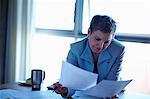 Mature businesswoman reading paperwork in office