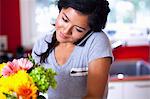 Young woman using cellular phone in kitchen