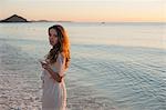 Portrait of young woman on beach at sunset, Castiadas, Sardinia, Italy