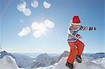 Young boy standing on pile of snow, in snowy landscape