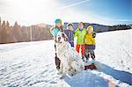 Children and pet dog enjoying playing in snow