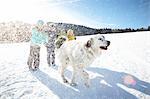 Children and pet dog enjoying playing in snow