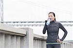 Female runner drinking on bridge, San Francisco, California