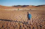 Boy walking in desert, Namib Naukluft National Park, Namib Desert, Sossusvlei, Dead Vlei, Africa