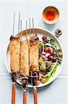 Spring rolls on skewers with salad and dipping sauce