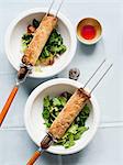 Spring rolls on skewers with salad bowls and dipping sauce
