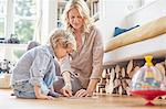 Mother and son sitting on floor, doing puzzle together