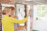 Women taking selfie in kitchen with cake